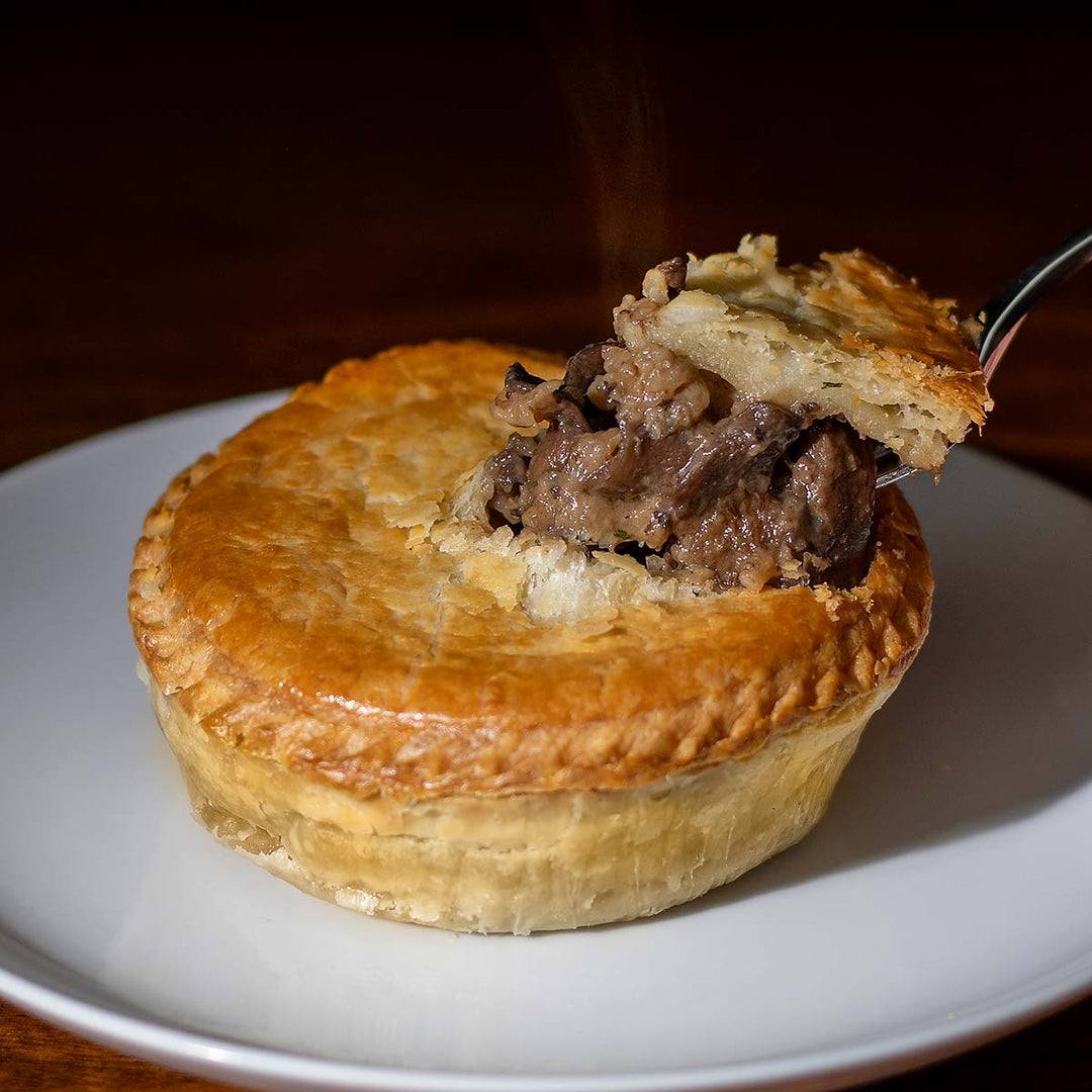 Steaming mushroom pot pie with a fork on a plate