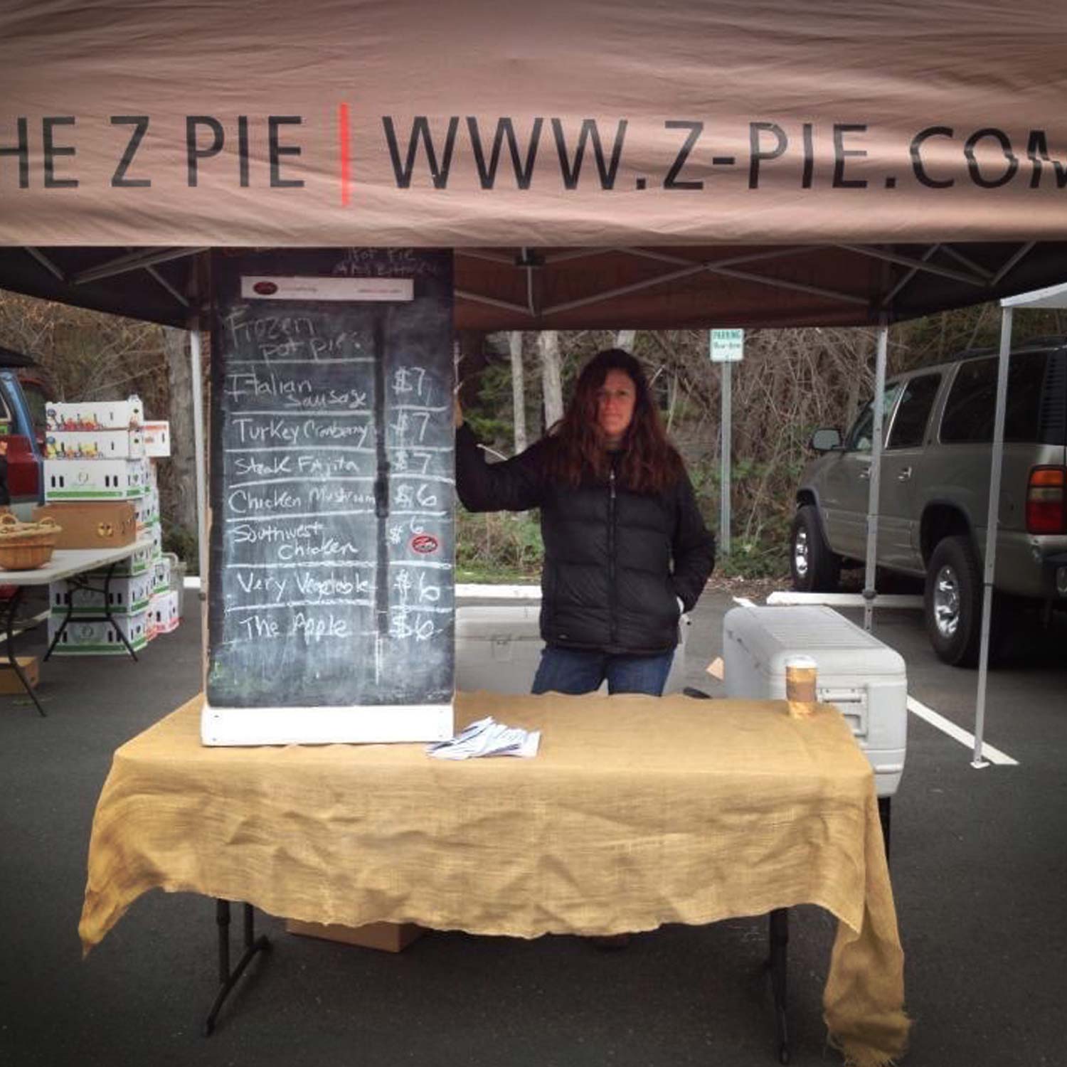 Marnie with chalkboard sign of available pot pies at a farmer's market in the 1990s